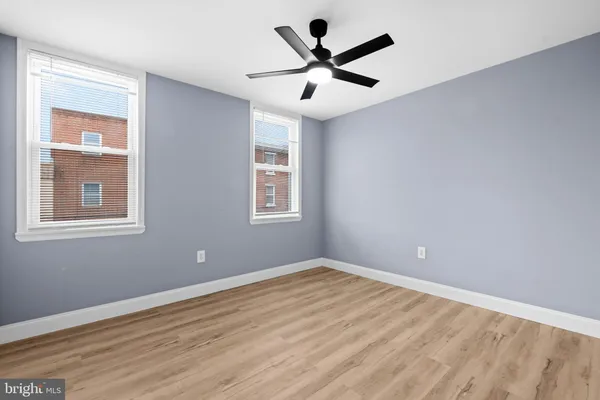 a view of a big room with wooden floor and windows