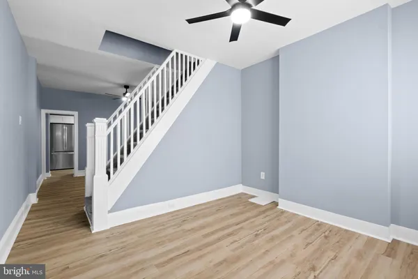 wooden floor in an empty room with a chandelier fan
