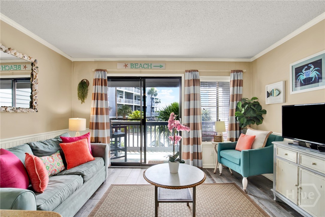 1217 Bay Street, Unit 105B Tybee Island, GA 31328 - Photo 4 of 46 Open Living Area with Sleeper Sofa & Plenty of Nat