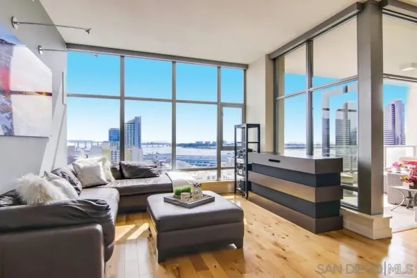 a living room with stainless steel appliances furniture and a kitchen view