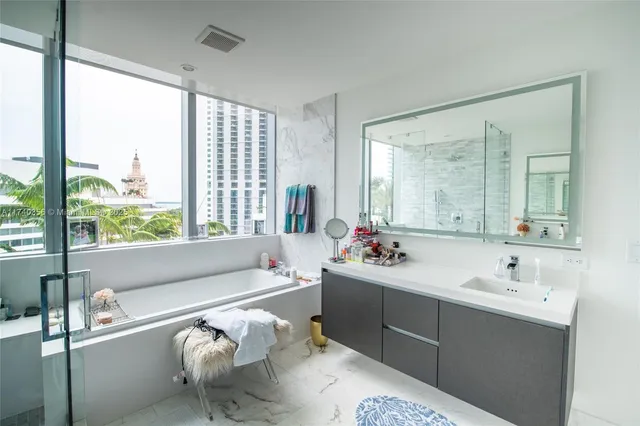 a en suite bathroom with a tub mirror and window