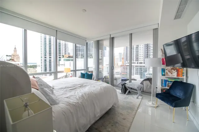 a bedroom with a bed and large window