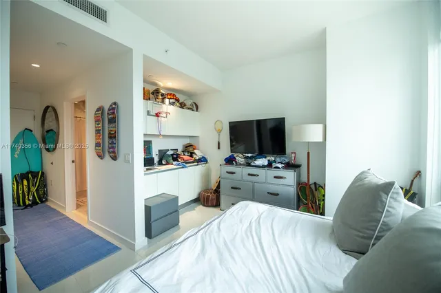 a bedroom with a bed and a flat screen tv