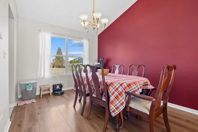 a bedroom with a bed and a dresser with wooden floor
