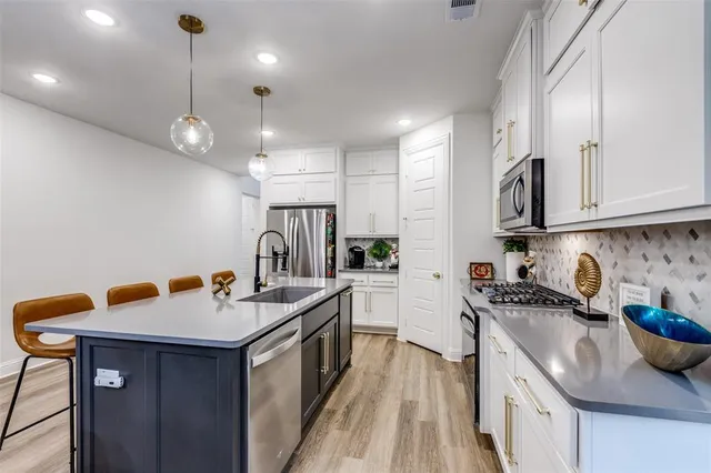 a kitchen with stainless steel appliances granite countertop a sink stove and cabinets