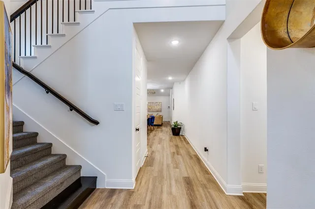 a view of a hallway with wooden floor and staircase