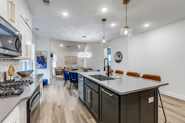 a kitchen with a stove a refrigerator and a dining table with wooden floor