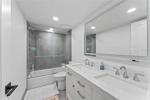 a bathroom with a double vanity sink toilet and shower