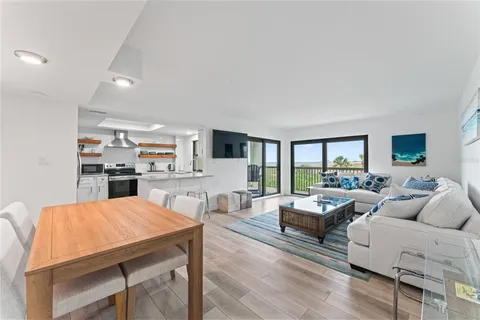 a living room with furniture wooden floor and a large window