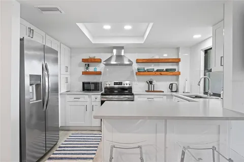 a kitchen with stainless steel appliances a refrigerator sink and stove