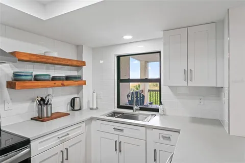 a kitchen with stainless steel appliances granite countertop a sink a stove and cabinets