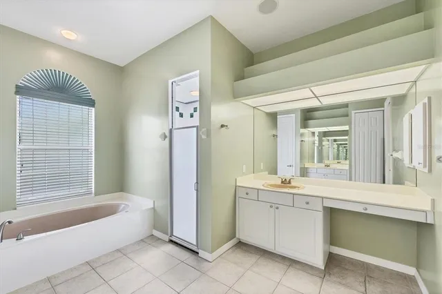 an empty room with chandelier fan and windows