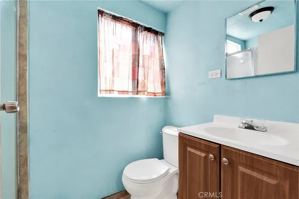 a bathroom with a toilet a sink and a window
