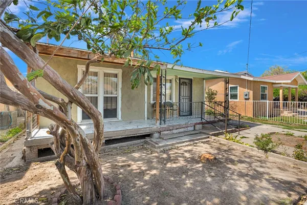 a view of a house with a large tree and wooden fence