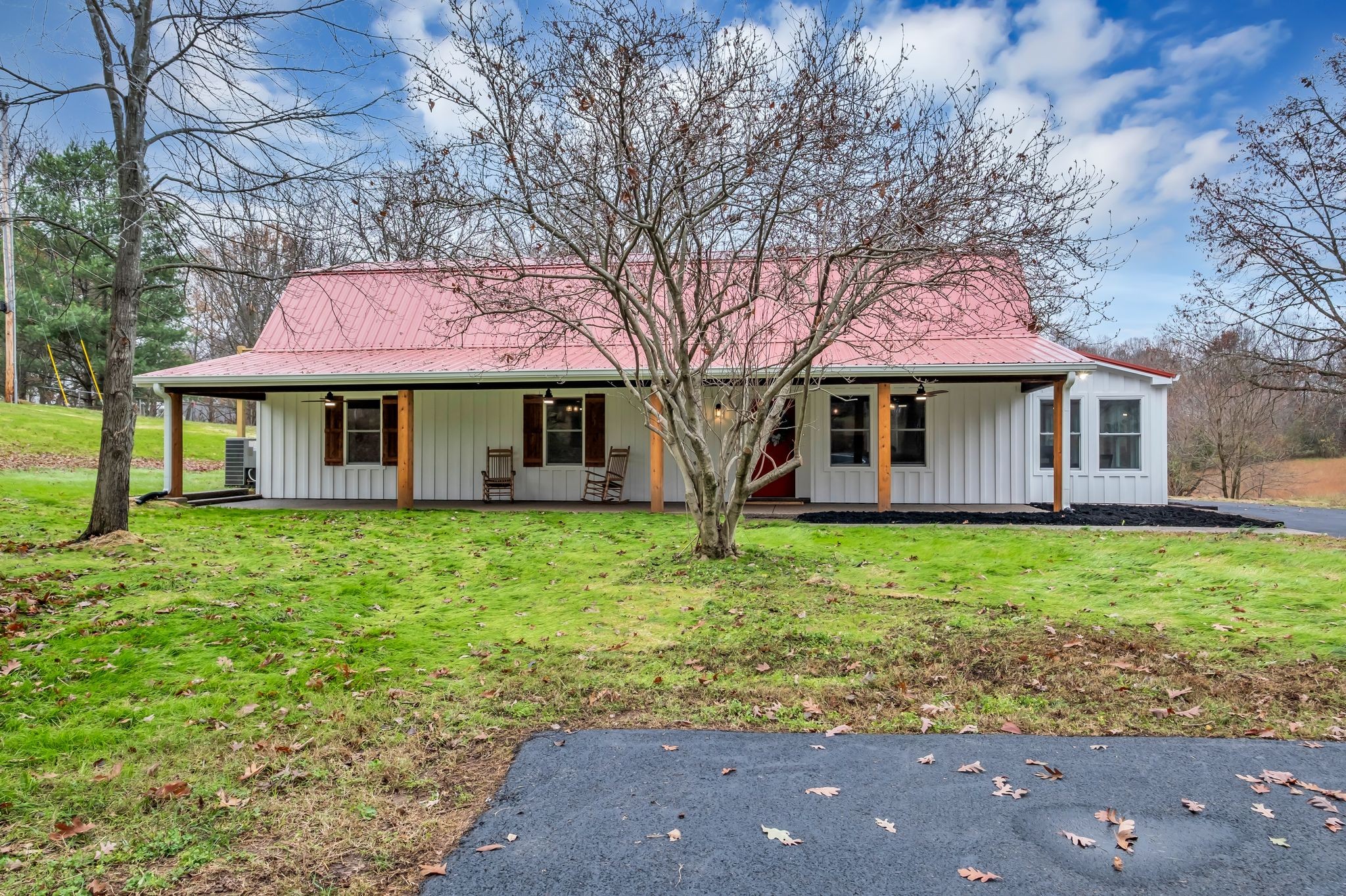 a view of a house with a yard and large tree