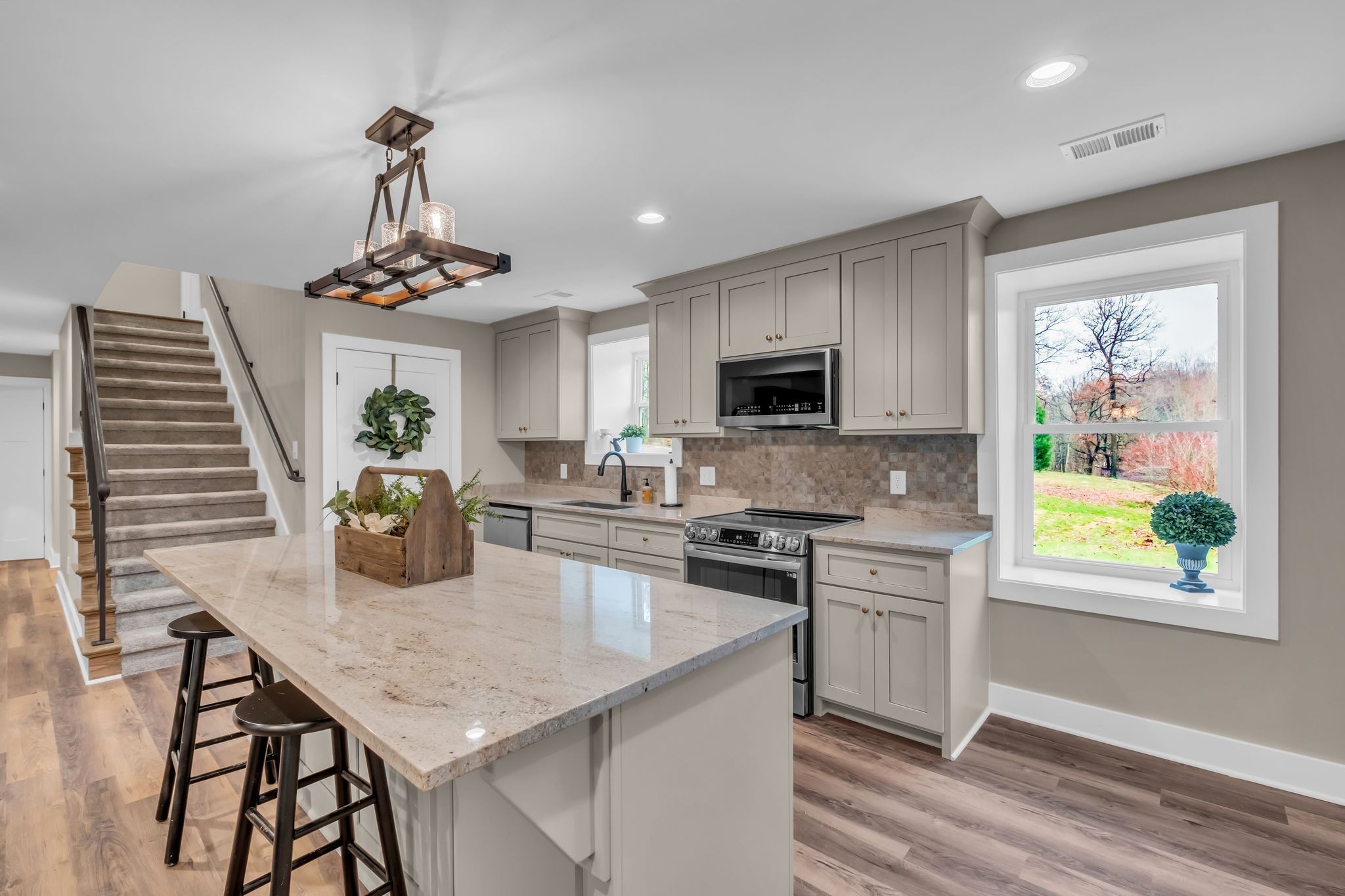 372 Lee Road Cottontown, TN 37048 - Photo 17 of 52 a kitchen with stainless steel appliances granite countertop a kitchen island hardwood floor sink stove dining table and chairs