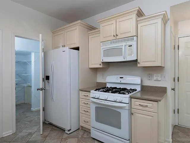 a kitchen with cabinets stainless steel appliances and a window