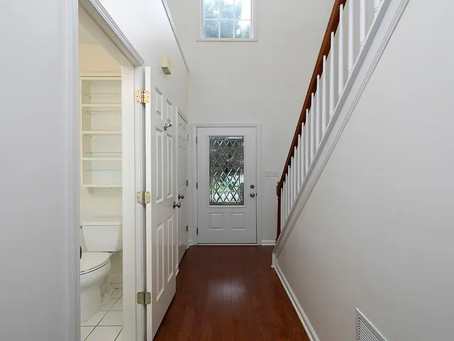 a view of a hallway with wooden floor and staircase