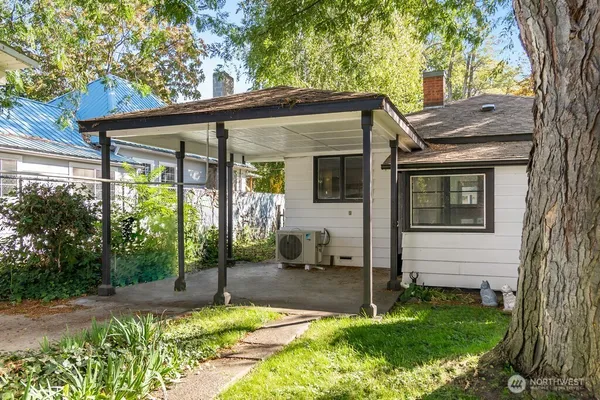 a backyard of a house with potted plants and large tree