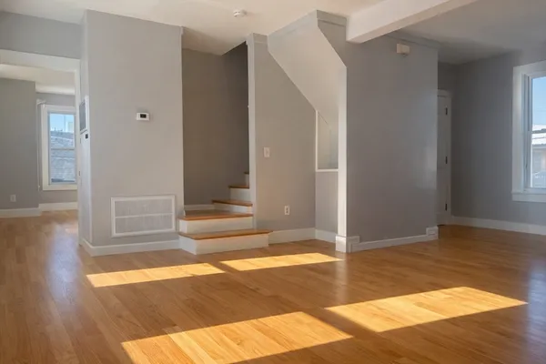 a view of a bedroom with wooden floor and white walls
