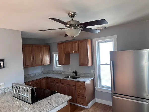 a kitchen with granite countertop a refrigerator a sink and dishwasher