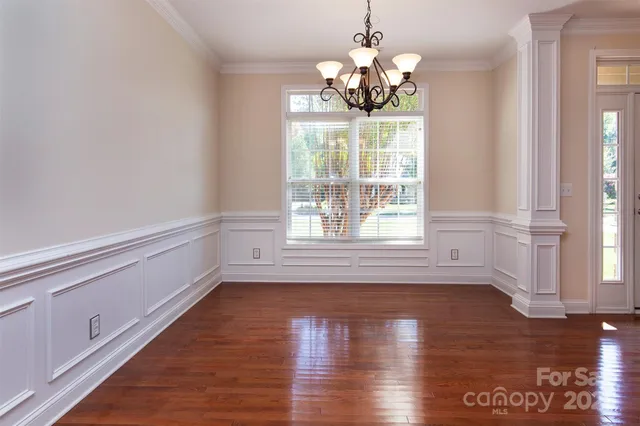 a view of a room with wooden flooring and chairs