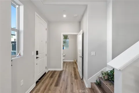 a view of a hallway with wooden floor and staircase