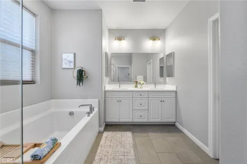 a spacious bathroom with a tub sink and mirror