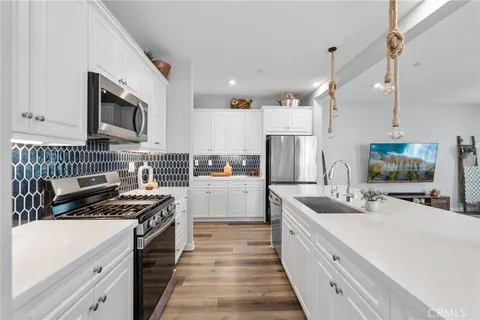 a kitchen with stainless steel appliances sink stove microwave and cabinets