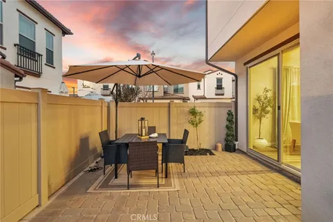 a patio with a table and chairs under an umbrella
