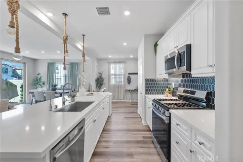 a large kitchen with stainless steel appliances lots of counter space and a sink