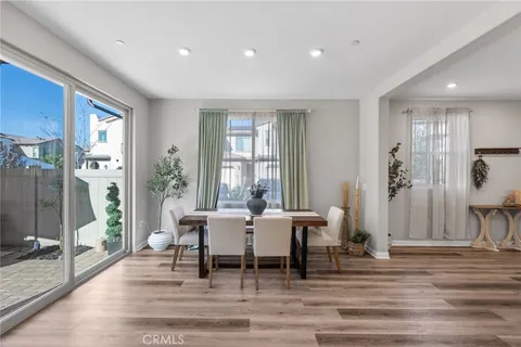 a dining room with wooden floor and a floor to ceiling window