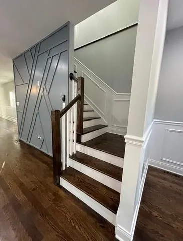 a view of staircase with wooden floor and white walls