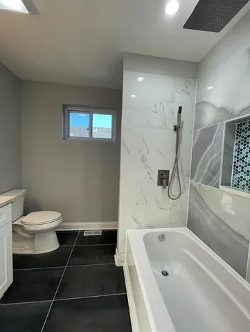 a bathroom with a bathtub and toilet