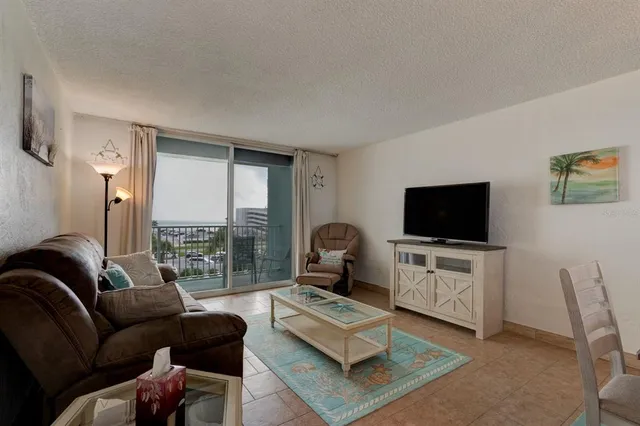 a living room with furniture a flat screen tv and a large window