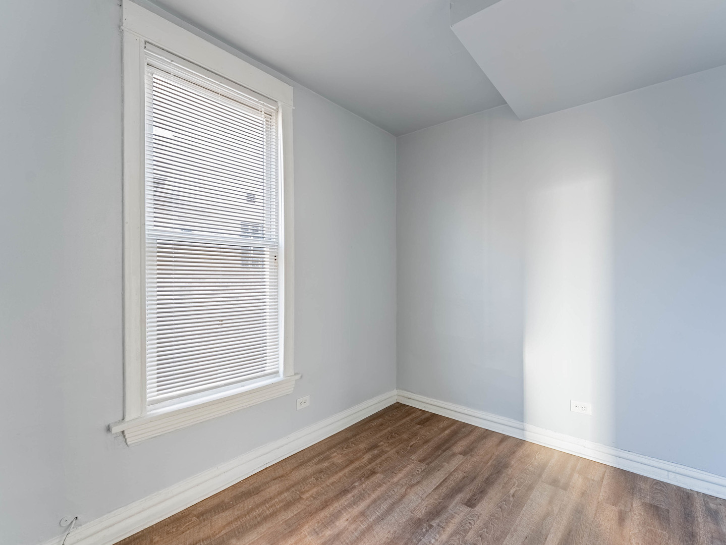 1521 Grove Avenue, Unit 1 Berwyn, IL 60402 - Photo 12 of 27 a view of an empty room with wooden floor and a window