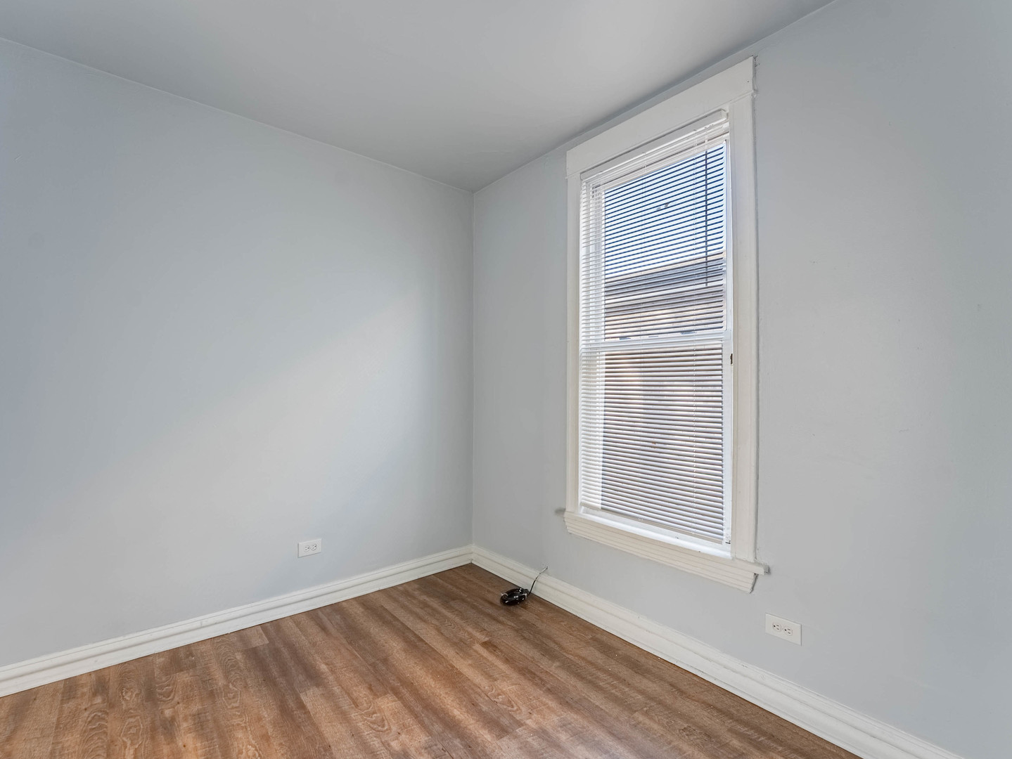 1521 Grove Avenue, Unit 1 Berwyn, IL 60402 - Photo 13 of 27 a view of an empty room with wooden floor and a window