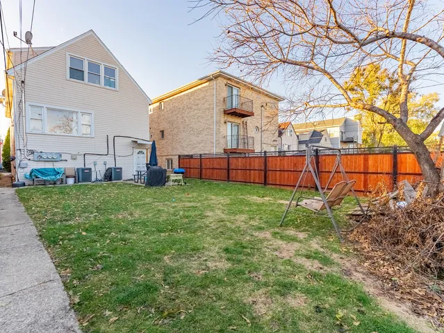 a view of backyard with wooden fence