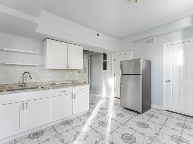 a kitchen with a refrigerator sink and cabinets