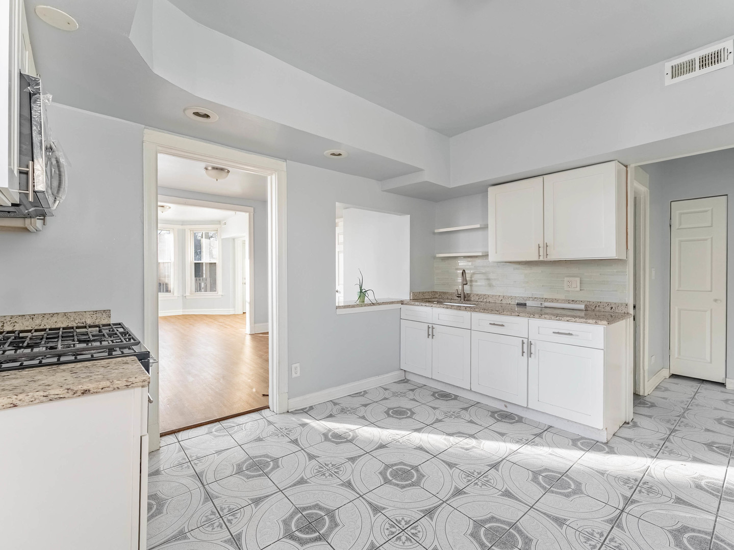 1521 Grove Avenue, Unit 1 Berwyn, IL 60402 - Photo 7 of 27 a kitchen with granite countertop a stove a sink and a refrigerator