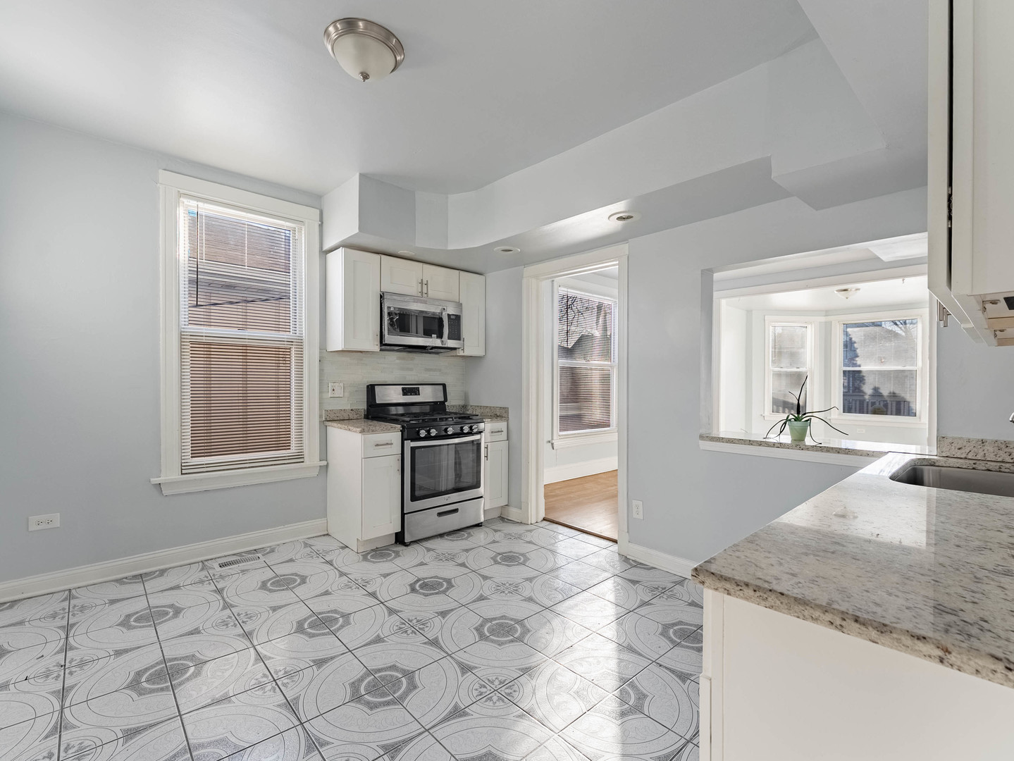 1521 Grove Avenue, Unit 1 Berwyn, IL 60402 - Photo 8 of 27 a kitchen with granite countertop a stove a sink and a refrigerator