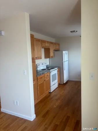 a kitchen with granite countertop a refrigerator and a stove top oven