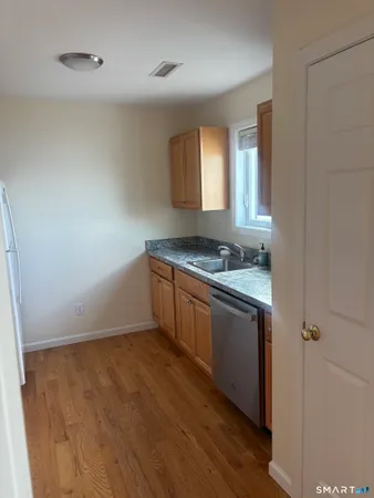 a kitchen with granite countertop a stove a sink and a refrigerator