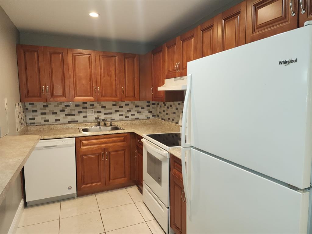 4174 Inverrary Drive, Unit 811 Lauderhill, FL 33319 - Photo 2 of 10 a kitchen with a stove top oven and cabinets