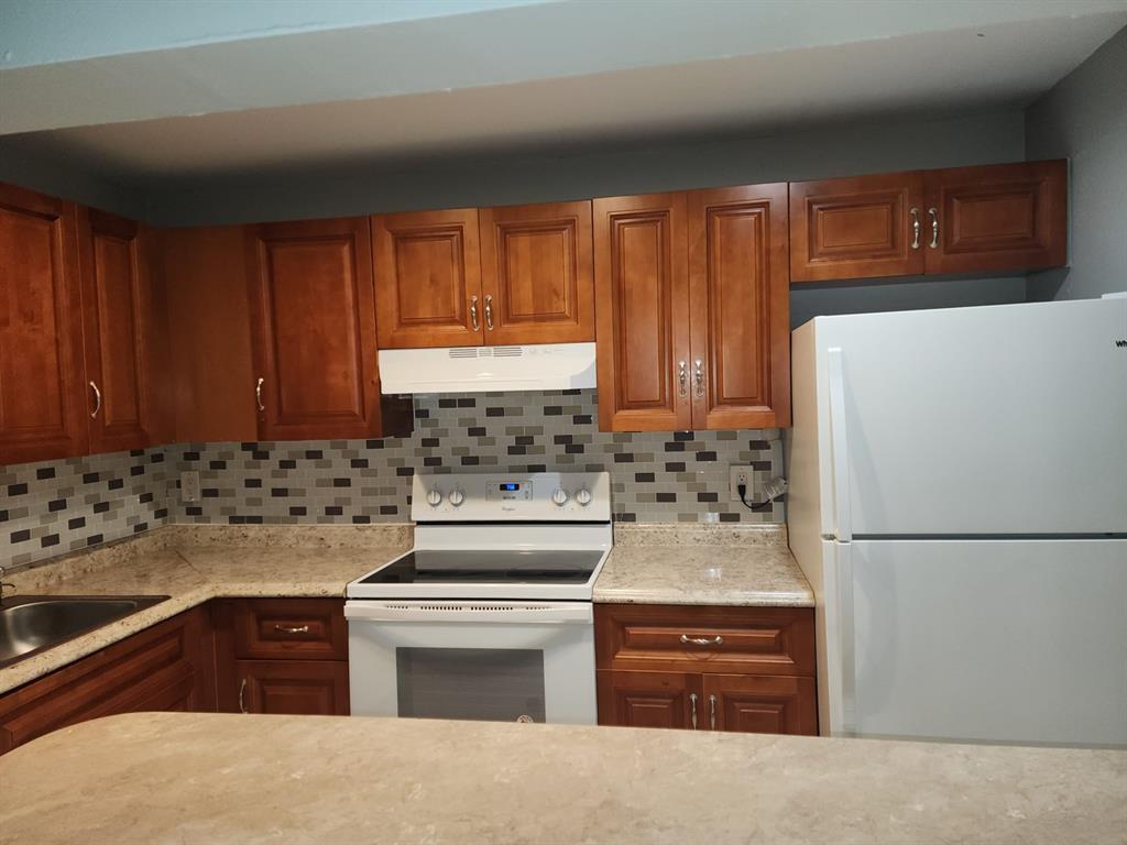4174 Inverrary Drive, Unit 811 Lauderhill, FL 33319 - Photo 3 of 10 a kitchen with granite countertop cabinets and refrigerator