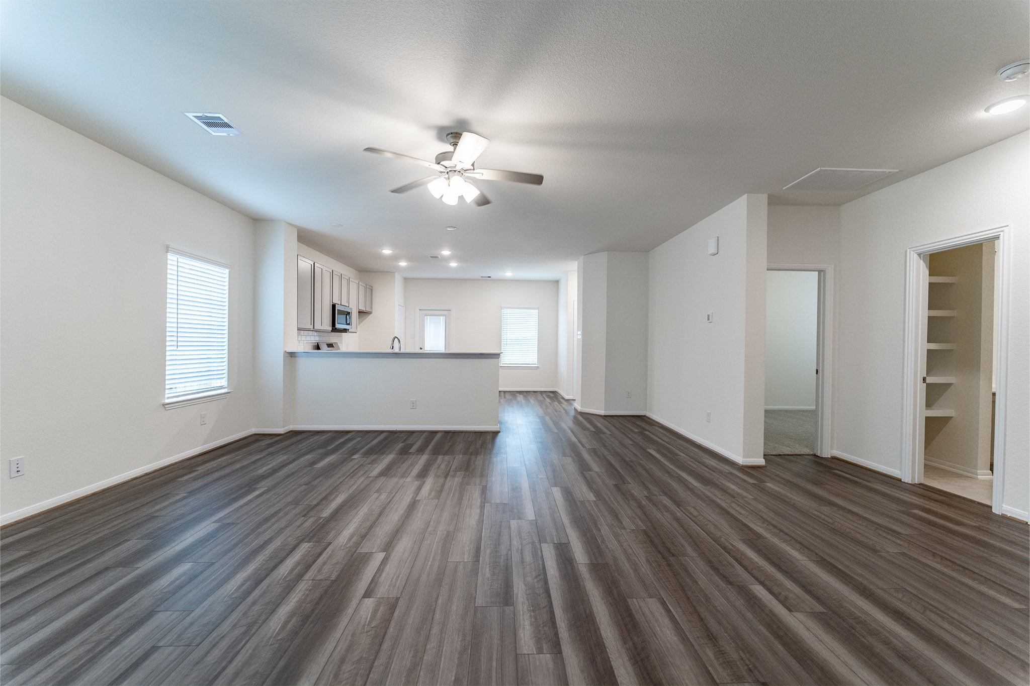 3527 Prairie Rose Trail Angleton, TX 77515 - Photo 11 of 19 a view of an empty room with wooden floor and a kitchen