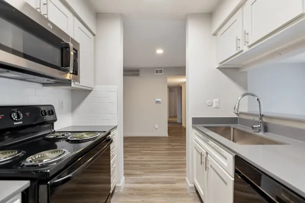 a kitchen with stainless steel appliances granite countertop a sink and a stove