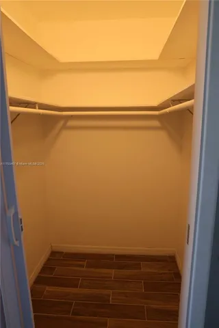 a view of closet with wooden floor