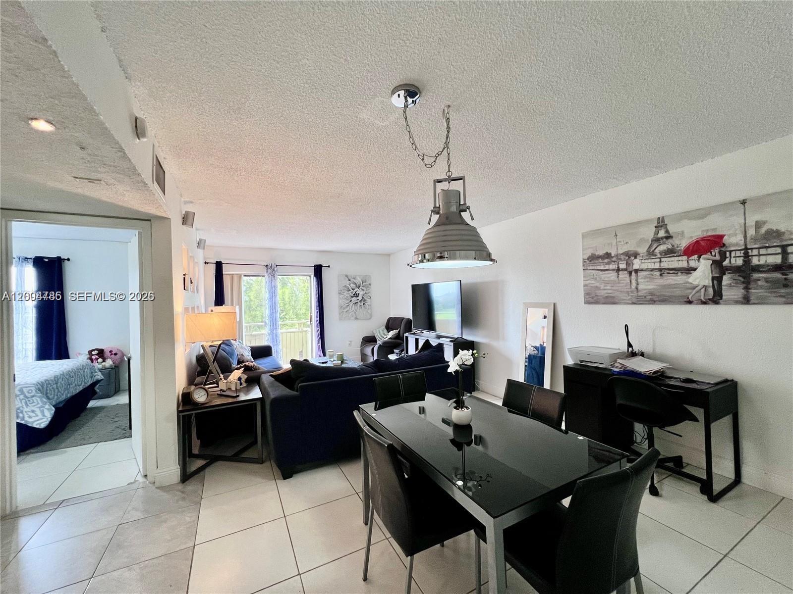 17530 Northwest 68th Avenue, Unit C4008 Hialeah, FL 33015 - Photo 13 of 26 a living room with furniture a rug and a table