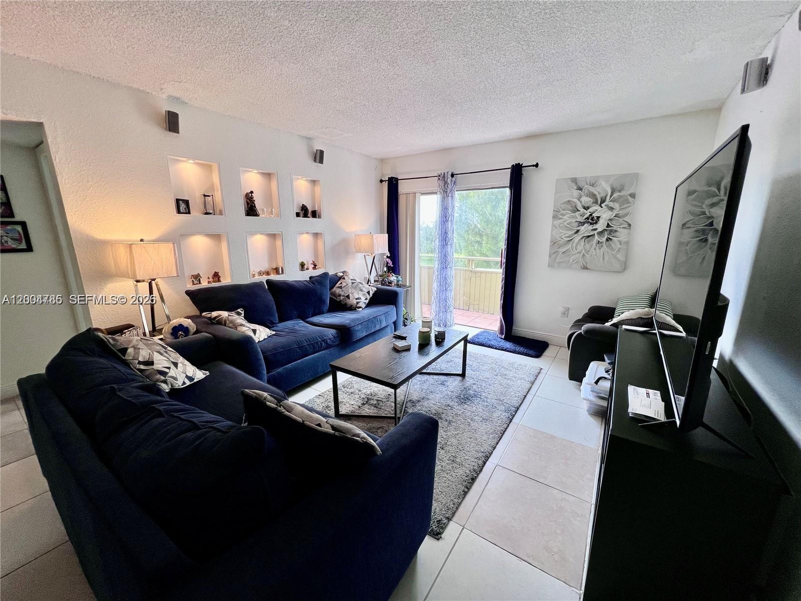 17530 Northwest 68th Avenue, Unit C4008 Hialeah, FL 33015 - Photo 16 of 26 a living room with furniture bathtub and a large window